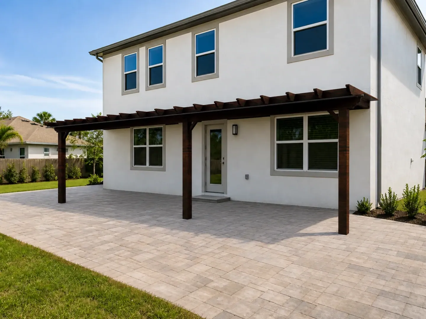 Visualization of a dark timber pergola extending across the paved terrace of a white house.